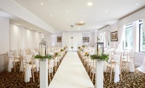a set up for a wedding in a room with tables and chairs at Macdonald Frimley Hall Hotel & Spa in Camberley +32 photos