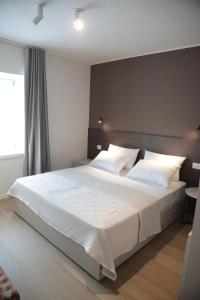 a bedroom with a large bed with white sheets and pillows at TAU Rooms Srl in Tricesimo +14 photos
