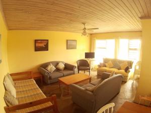 a living room with couches chairs and a table at Anchorage Cottage & The Moorings in Cape St Francis