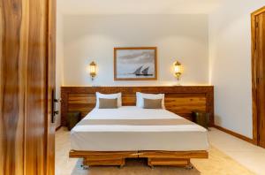 a bedroom with a large bed with two pillows at Halisi Villas in Nungwi