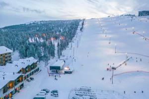 a snow covered ski slope with people on it at Cranberry C11 Levi Center incl 2 ski passes by Aavalevi in Levi