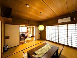a living room with a table and some windows at 伊東旅館 禅- Zen - in Ito