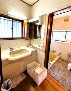 a bathroom with a tub and a sink and a bath tub at 伊東旅館 禅- Zen - in Ito +26 photos