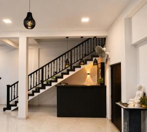 a staircase in a living room with a black stair case at Janri Villa in Tangalle