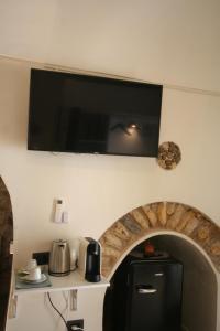 a flat screen tv hanging on a wall above a kitchen at Spago rooms 2 in Vieste