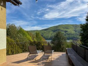 two chairs on a deck with a view of a lake at Willa Wypoczynkowa in Międzybrodzie Bialskie