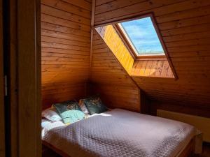 a bedroom with a bed in a wooden room with a window at Willa Wypoczynkowa in Międzybrodzie Bialskie
