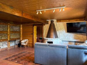 a living room with a stone fireplace and blue chairs at Willa Wypoczynkowa in Międzybrodzie Bialskie