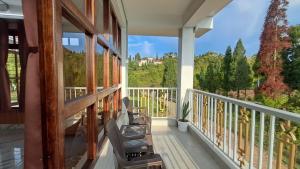 a balcony with chairs and a view of the mountains at Red Cherry Homestay, Nokdara in Lava