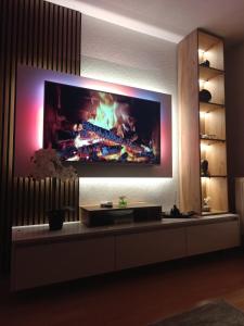 a living room with a fireplace on the wall at Apartment Alan - Modern Stay in Travnik