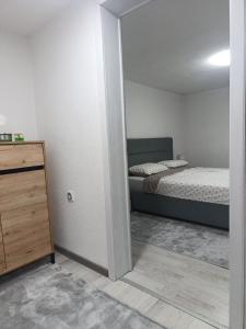 a bedroom with a bed and a dresser in it at Apartment Alan - Modern Stay in Travnik