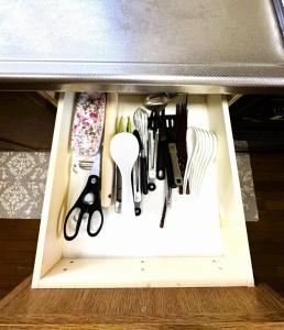 a drawer filled with knives and other kitchen utensils at 伊東旅館 禅- Zen - in Ito