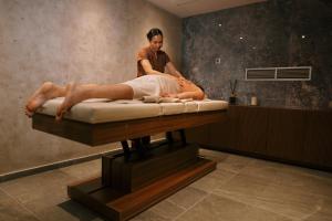 a woman sitting on a bed with a man on it at New City Hotel & Restaurant Niš in Niš