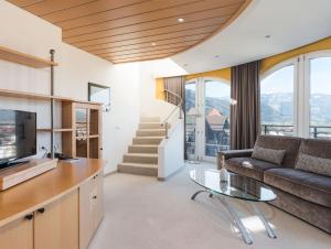 a living room with a couch and a table at Hotel Montis - Active Nature Resort in Brunico