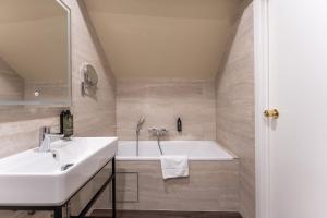 a bathroom with a sink and a bath tub at Hotel 't Putje in Bruges