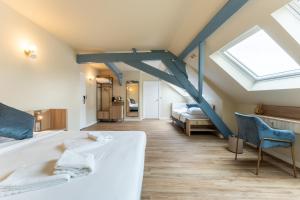 a bedroom with a large white bed and a skylight at Hotel 't Putje in Bruges