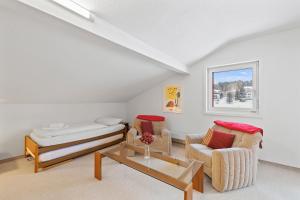 a living room with two chairs and a bed at Triangel A Freund in Parpan