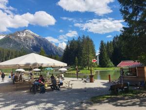 a group of people sitting at tables near a lake at Belmont Seegarten in Lenzerheide