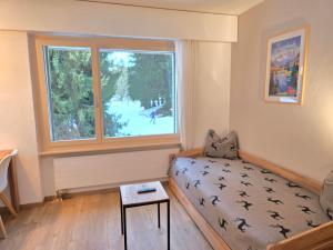 a living room with a couch and a window at Belmont Seegarten in Lenzerheide