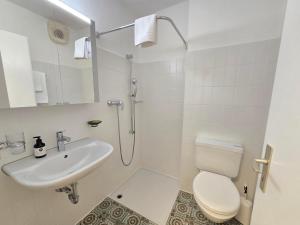 a bathroom with a toilet and a sink and a shower at Belmont Seegarten in Lenzerheide +36 photos