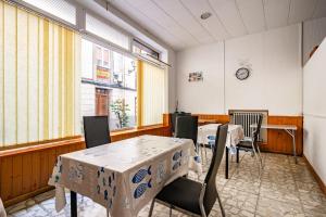 a dining room with tables and chairs and windows at Hostal Oria in Luarca