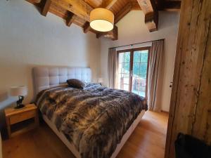 a bedroom with a bed and a large window at Ferienwohnung Selina in Lenzerheide