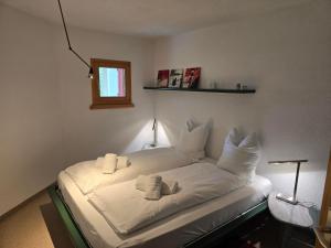 a bed with white sheets and pillows in a room at Ferienwohnung Selva in Lenzerheide