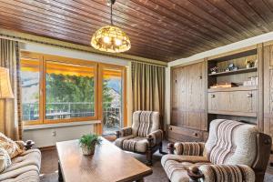 a living room with two chairs and a table and a window at Triangel D Grossenberger in Parpan