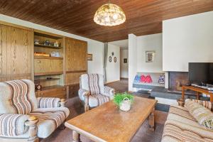 a living room with two chairs and a table at Triangel D Grossenberger in Parpan +12 photos