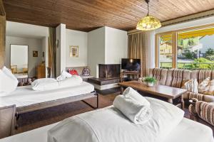 a hotel room with two beds and a couch at Triangel D Grossenberger in Parpan