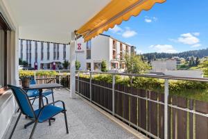 a patio with a table and chairs on a balcony at Triangel D Grossenberger in Parpan