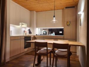 a kitchen with a wooden table and chairs at Triangel C Kiefer in Parpan