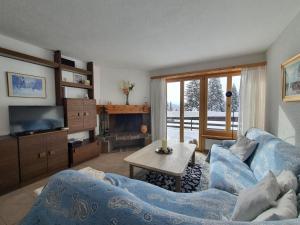 a living room with a couch and a tv at La Schmetta 65 Quadroni in Lenzerheide
