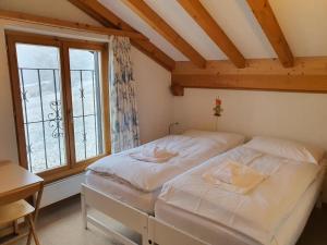 a bedroom with two beds in front of a window at La Schmetta 65 Quadroni in Lenzerheide