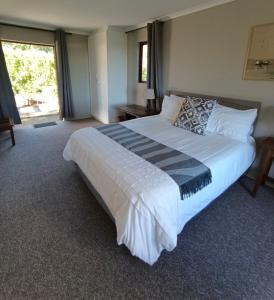 a large bedroom with a large bed with white sheets at Valley View the home with a view in Nottingham Road