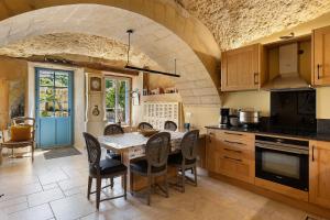 a kitchen with a table and chairs in a room at Les Iris - Maison Troglodytique in Trôo