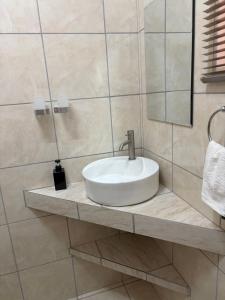 a bathroom with a sink and a mirror at Pooltjie's Self-catering Overnight in Keetmanshoop