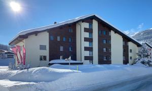 a large building with snow in front of it at Triangel B Rezia in Parpan