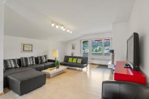 a living room with a couch and a tv at Triangel B Rezia in Parpan