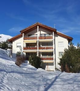 a large building with snow in front of it at Clois B Loughlin in Lenzerheide
