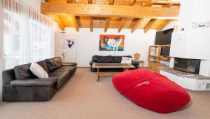 a living room with a couch and a red rug at Clois B Loughlin in Lenzerheide