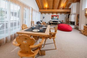 a dining room with a wooden table and chairs at Clois B Loughlin in Lenzerheide