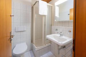 a white bathroom with a sink and a toilet at Clois B Loughlin in Lenzerheide +15 photos