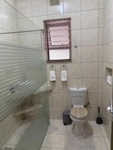a bathroom with a toilet and a window at Pooltjie's Self-catering Overnight in Keetmanshoop