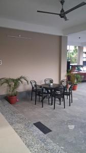 a patio with a table and chairs and a fan at Royal Homestay Siliguri in Silīguri Junction