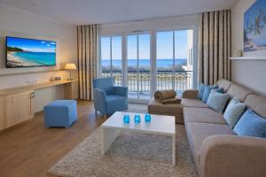 a living room with a couch and a table at Aparthotel Waterkant Suites - Fewos am Meer mit SPA in Börgerende-Rethwisch