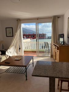 a living room with a table and a view of a balcony at VV Monica 33 "by AFCVacacional" in Puerto Naos