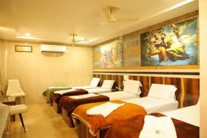a room with four beds and a painting on the wall at SSR Hotel in Srikalahasti +55 photos