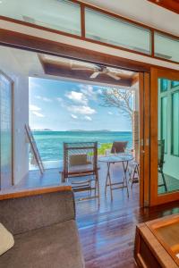 a living room with a view of the ocean at The Sarann Koh Samui, Suites & Villas in Chaweng Noi Beach