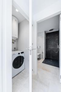 a white kitchen with a washing machine and a sink at Sunrise Center Suites in Torrevieja